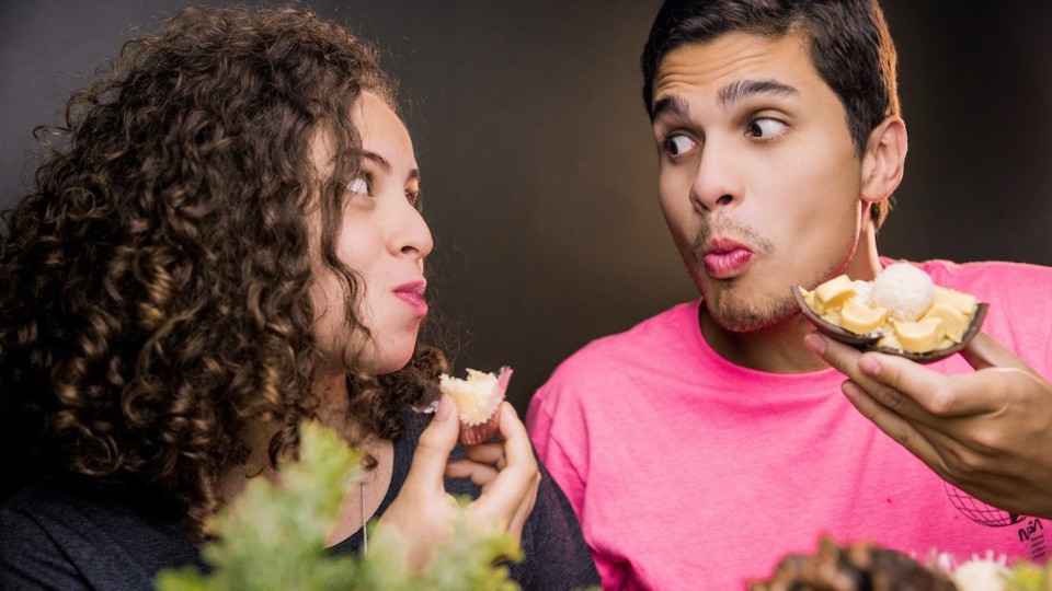 homme et femme mangeant en se regardant