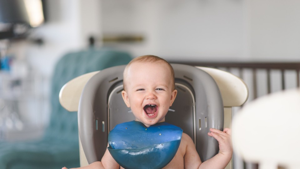 bébé souriant sur la chaise haute