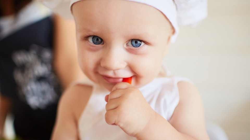 enfant aux yeux bleus avec une toque de cuisinier