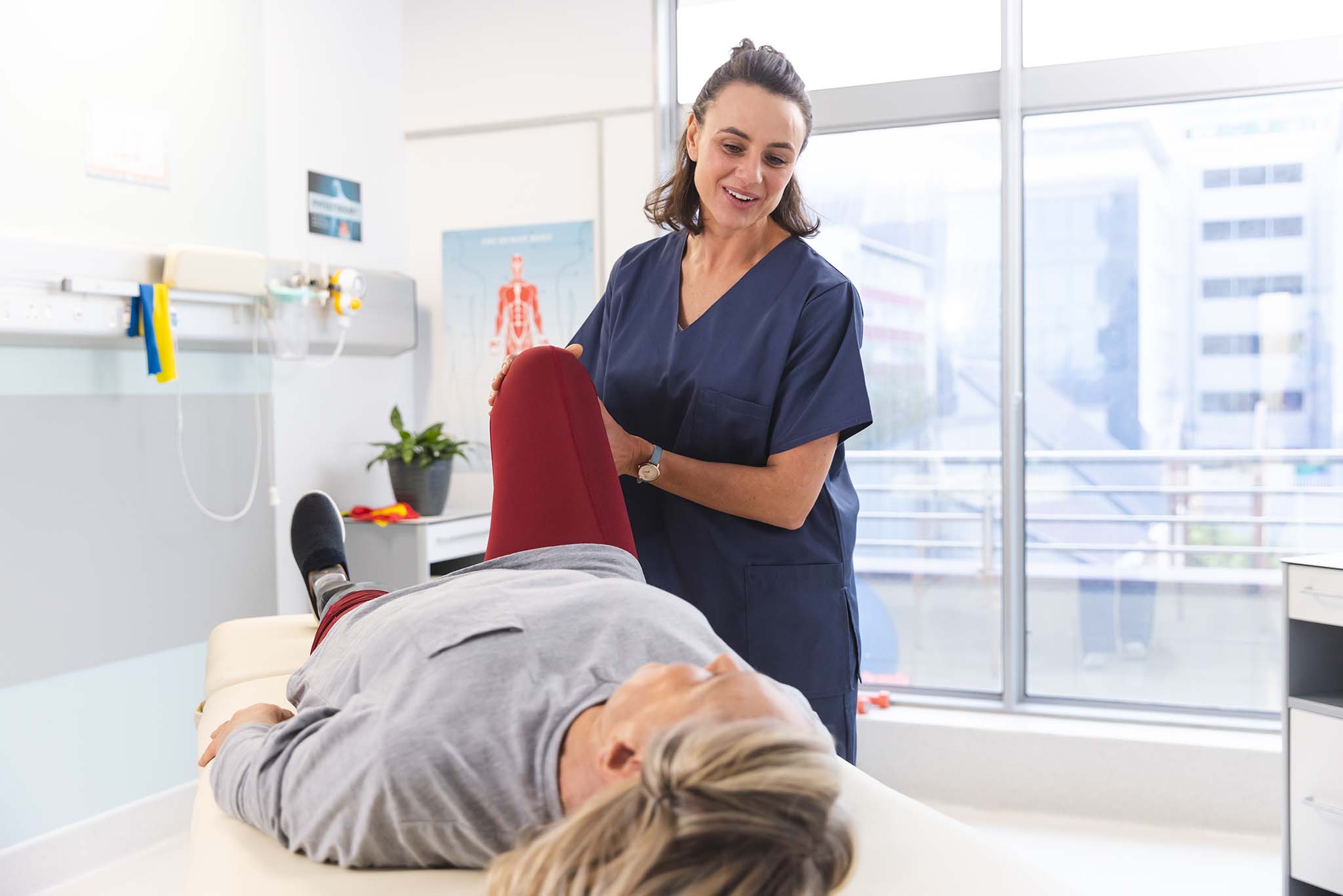 Physiotherapist assisting a patient with a leg stretch -  Physiothérapeute aidant un patient à étirer la jambe