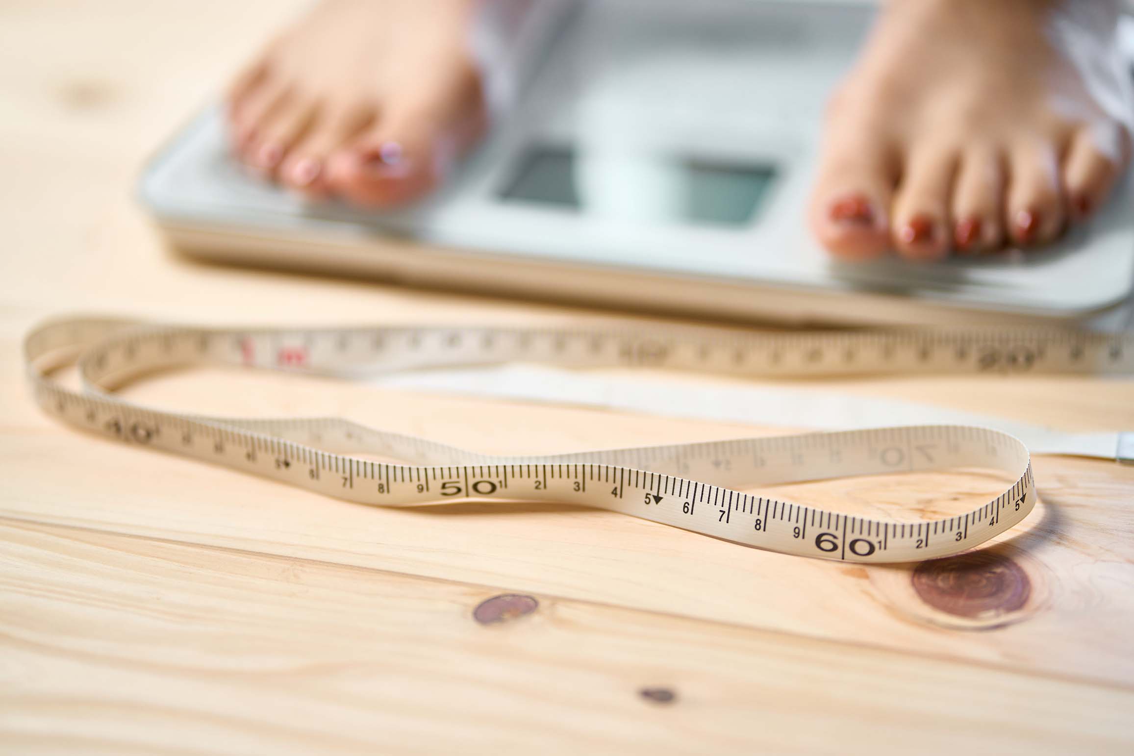 Pieds sur une balance avec ruban à mesurer - Feet on scale with measuring tape