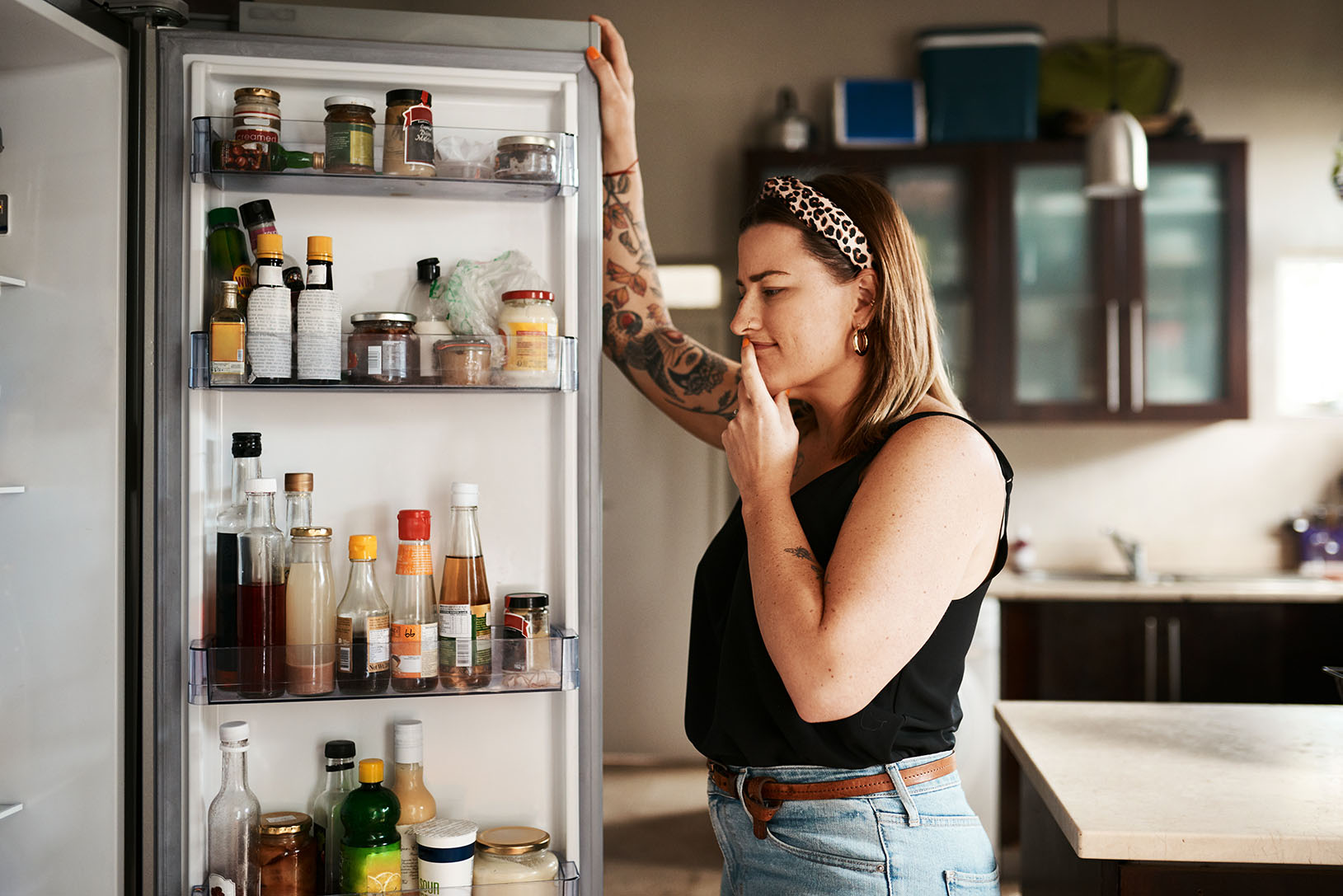 Femme regardant dans le réfrigérateur - Woman looking at fridge content