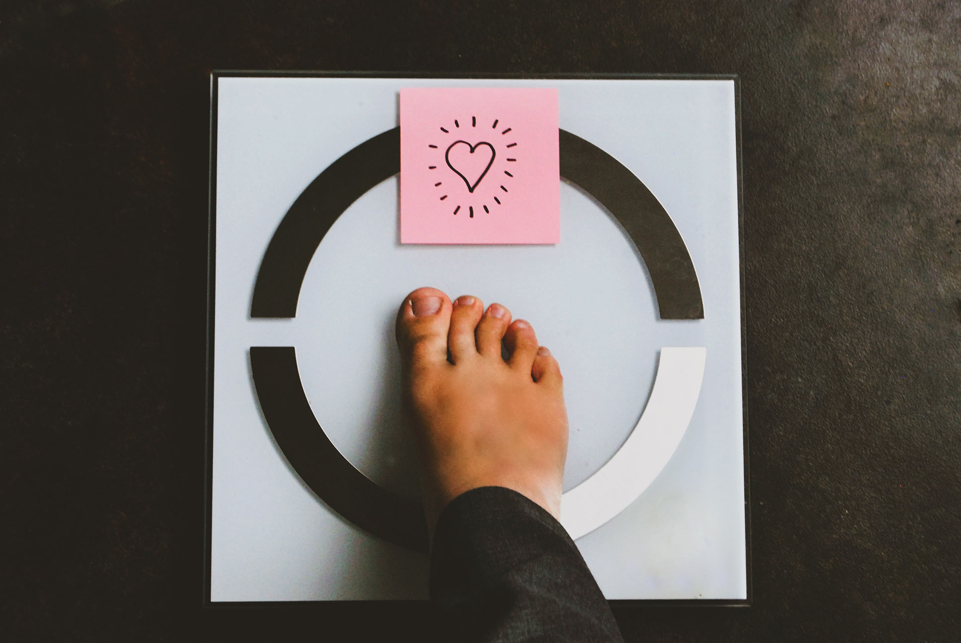 Pied sur une balance avec post it coeur - Foot on scale with a heart post it