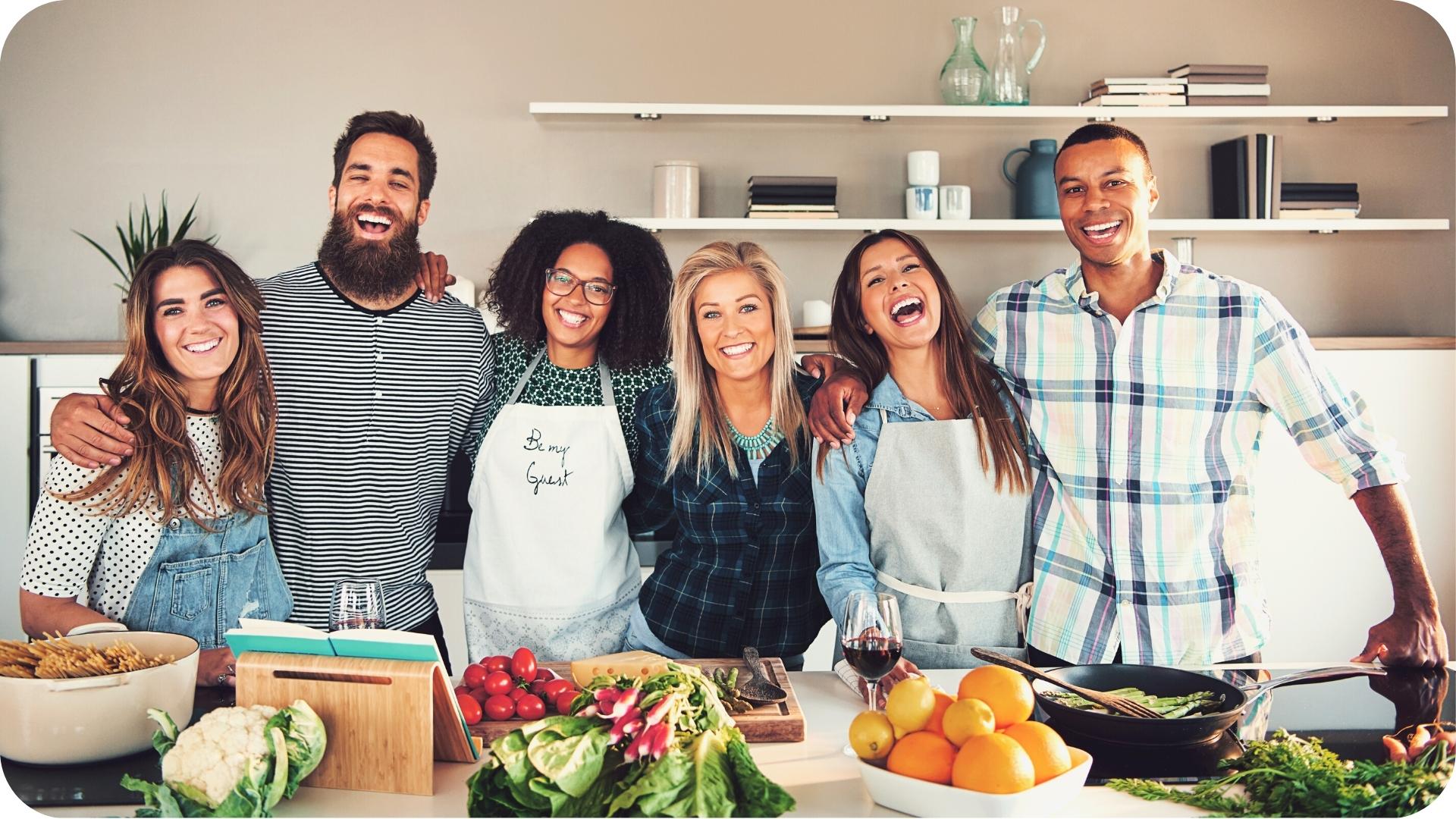 Smiling group of friends at a cooking workshop in a kitchen