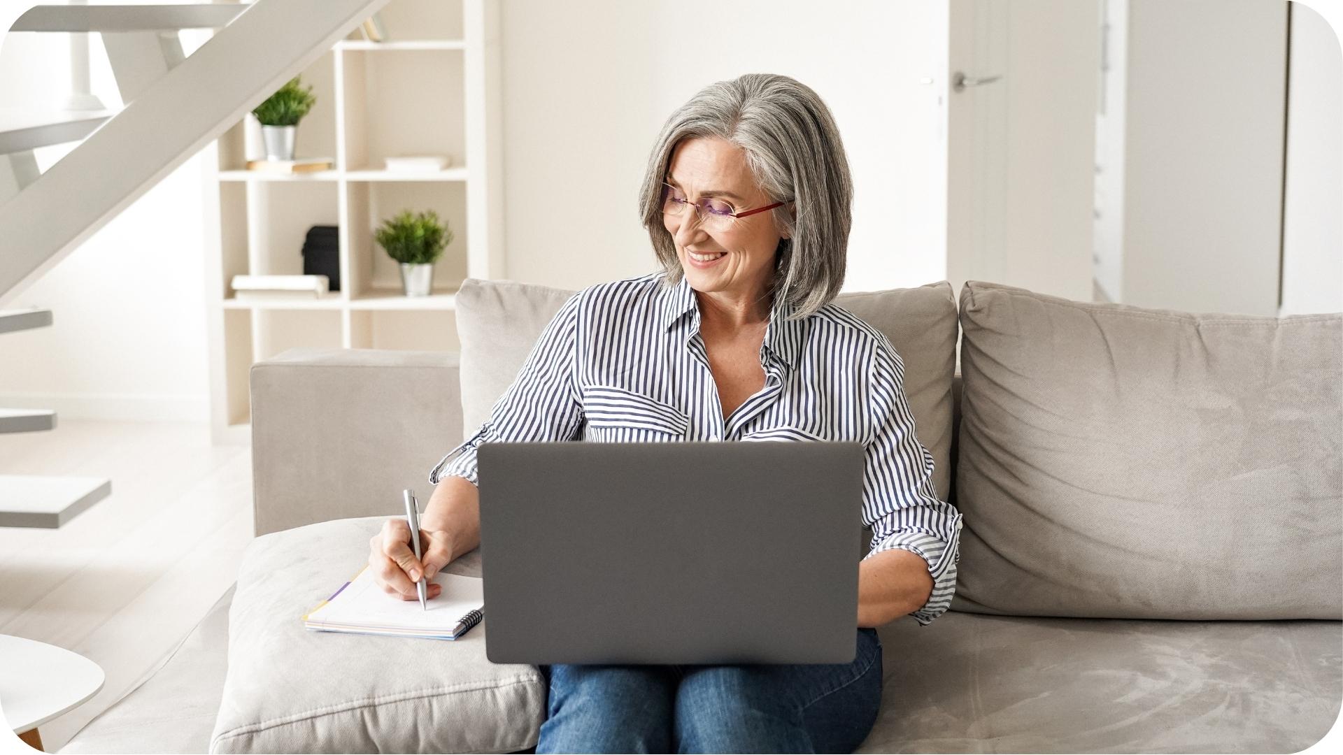 Femme souriante prenant des notes lors d’une consultation en ligne avec une nutritionniste