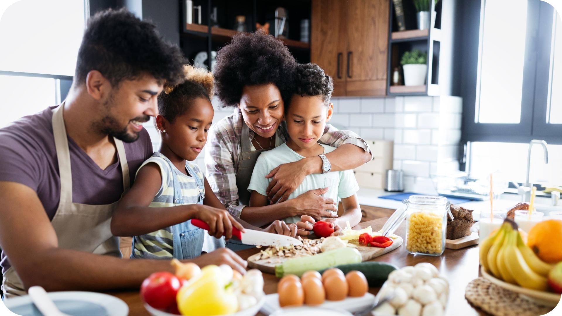 Famille préparant un repas ensemble dans la cuisine avec des légumes frais et des ingrédients sains