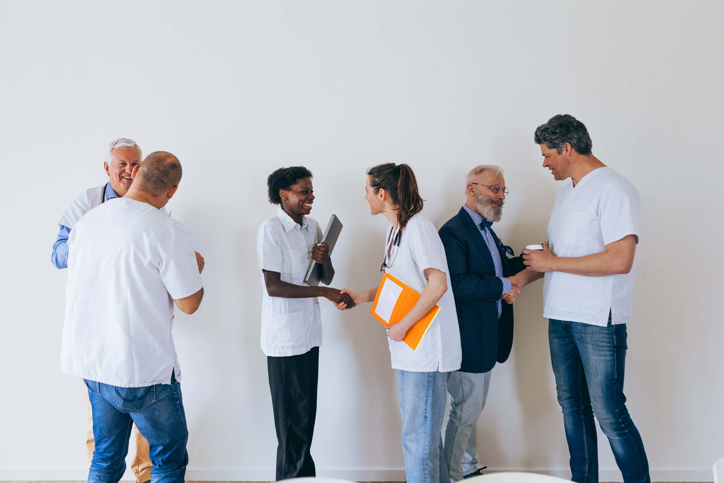 Group of healthcare professionals discussing and greeting each other in a bright space