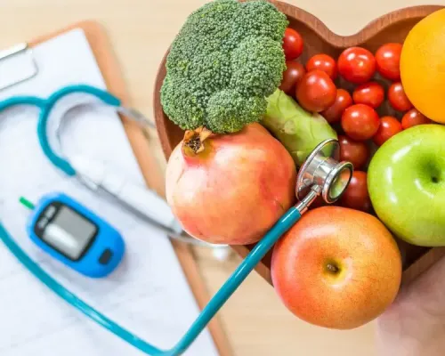 Triglycérides : des gestes concrets pour un taux plus sain. a person holding a stethoscope next to a bowl of fruits and vegetables