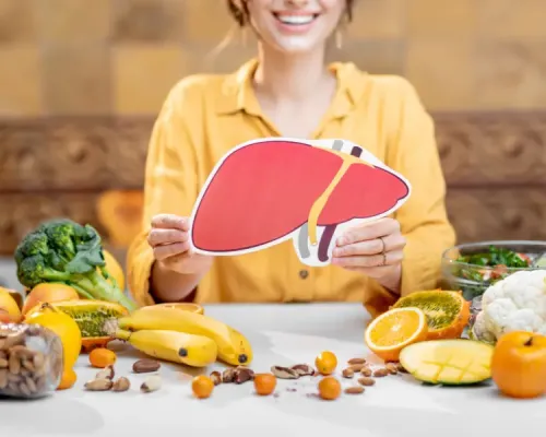 A person holding up a liver surrounded by fruits and vegetables. Nutritionnistes : acteurs clés de la  gestion de la stéatose hépatique métabolique