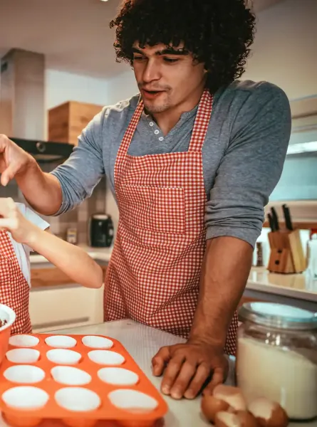 Famille souriante en train de cuisiner un dessert - Smiling family cooking a dessert together
